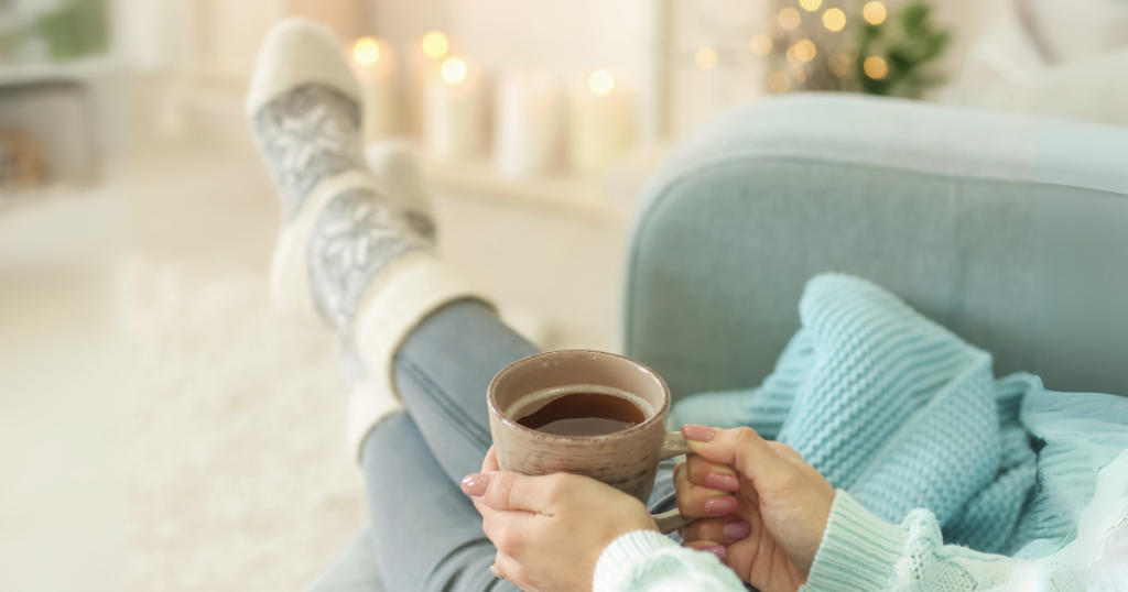 温かい飲み物を飲みながら一息つく女性